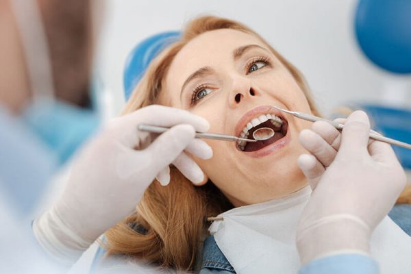 Middle-aged female patient getting her teeth cleaned